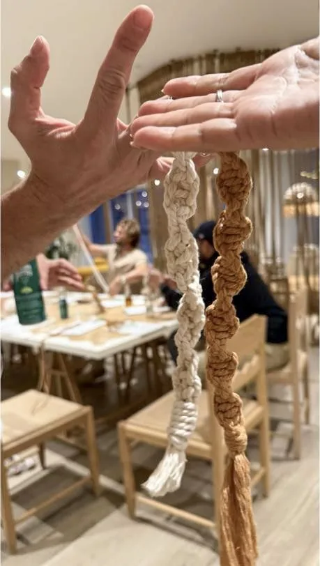 Hands knotting macrame during a beginner workshop at Flow Brickell, Miami