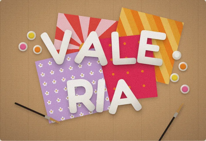 Valeria plaster name sign in soft white letters on a flat-lay of patterned paper
